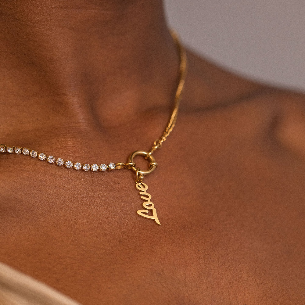 PURELEI Love Charm Anhänger aus 18K Gold, filigran, elegant am Hals getragen, feminine Leichtigkeit und Liebe.