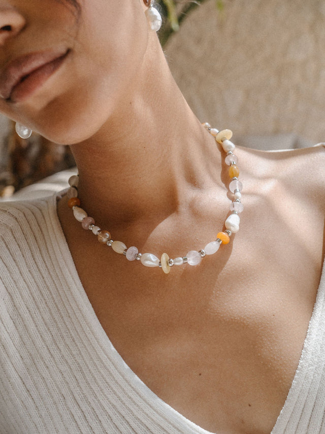 Perlenkette mit Muscheldetails, getragen in warmem Licht, von PURELEI.