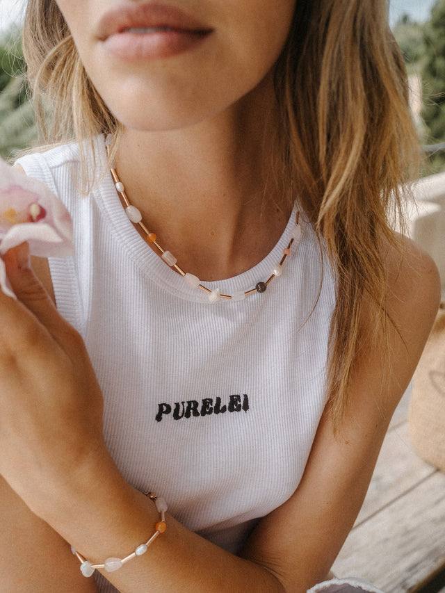 Bunte PURELEI Kette mit Muscheln und goldenen Akzenten, getragen in entspannter Atmosphäre.