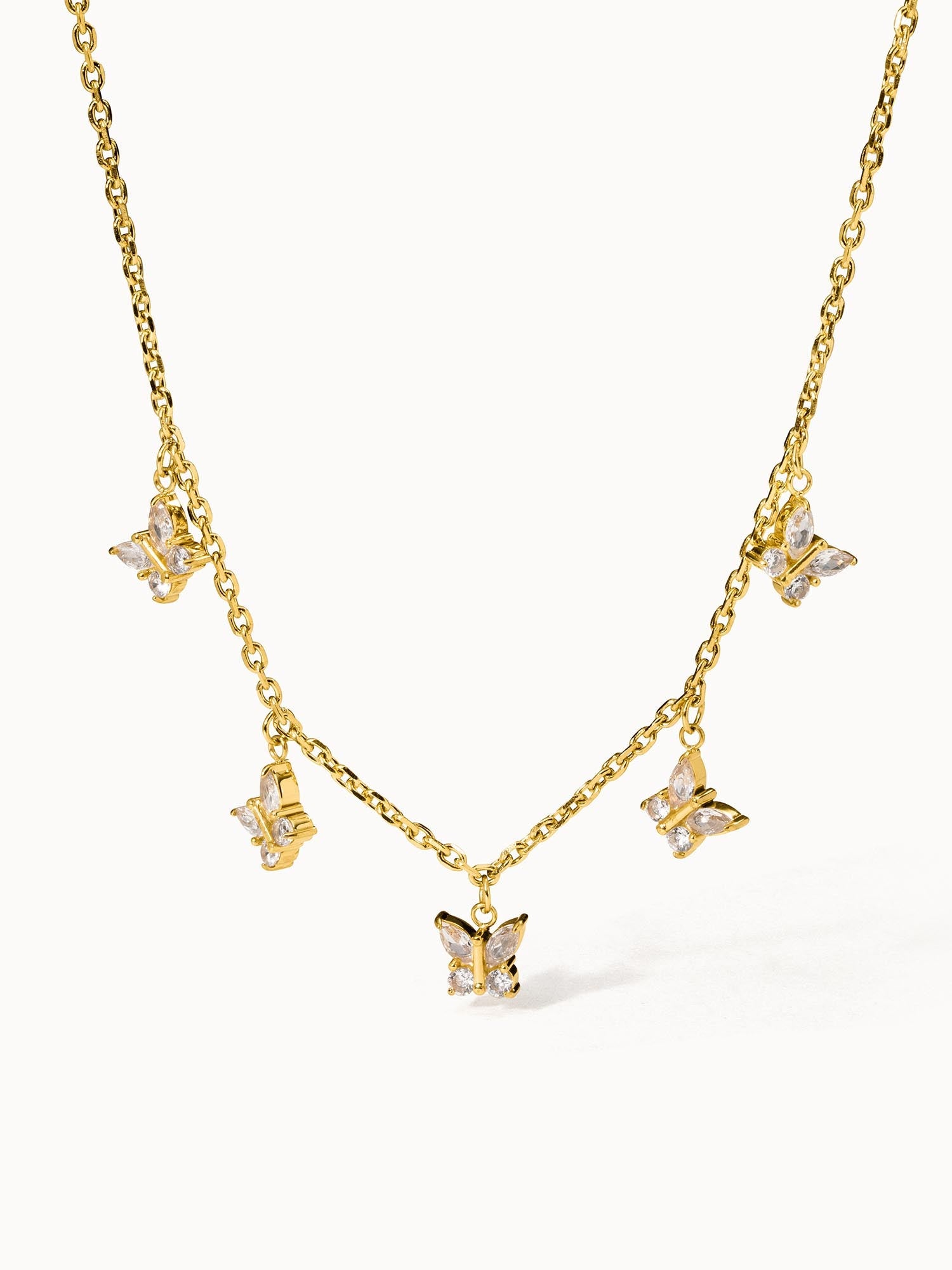 Goldene Kette mit Schmetterlings-Anhängern von PURELEI, elegant und verspielt.