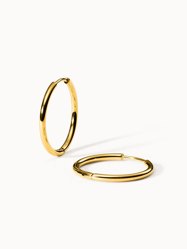 Goldene Creolen von PURELEI mit glänzender Oberfläche, elegant und modern.