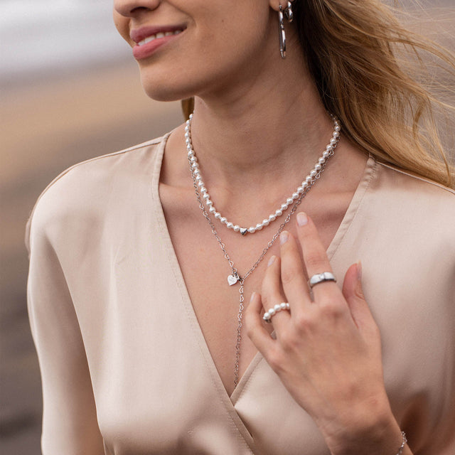 Zarte PURELEI Perlenkette und Silberring, elegant und feminin, in sanfter Lichtstimmung.