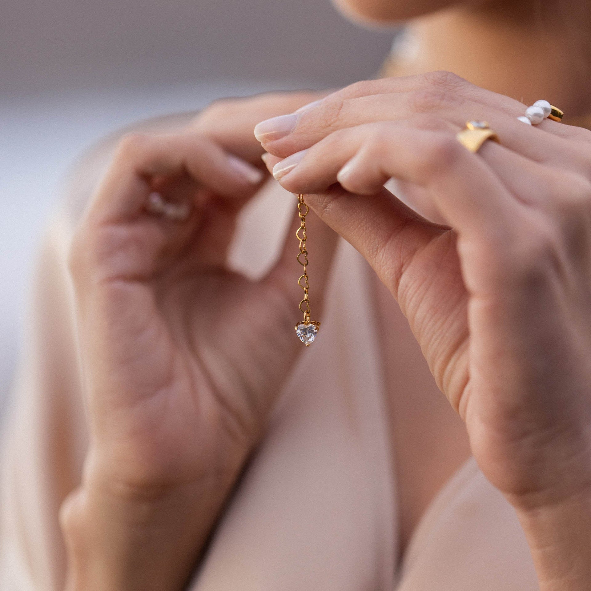 Roségoldenes Herz-Anhänger mit Kristall, elegant in der Hand gehalten – PURELEI.