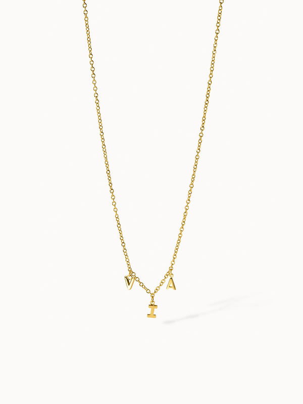 Goldene PURELEI Kette mit Buchstabenanhängern, elegant und verspielt.