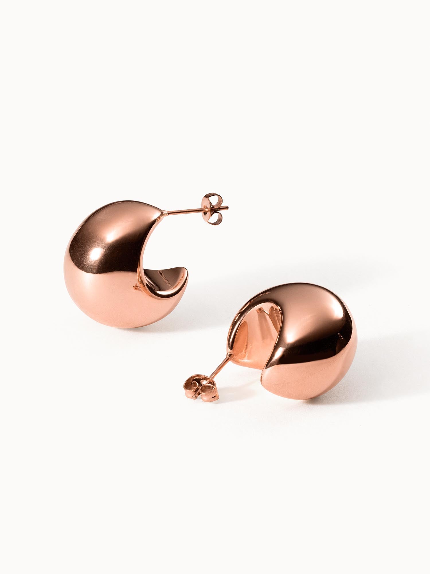 Roségoldene Creolen mit geschwungenem Design von PURELEI, elegant und modern.