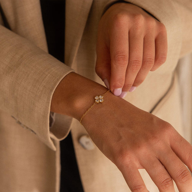 Roségoldenes Armband mit blütenförmigem Anhänger, getragen in eleganter Umgebung - PURELEI.