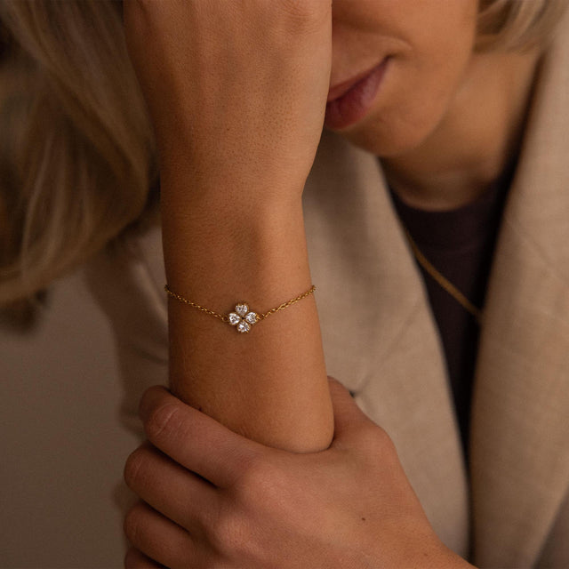 Zartes, goldfarbenes Armband mit floralen Details, getragen am Handgelenk, PURELEI.