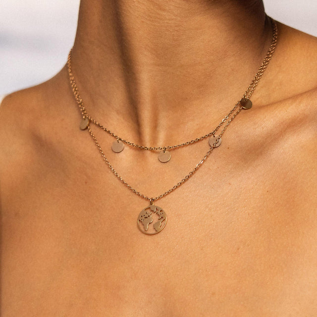 Goldene Kette mit Weltanhänger und Kreisen, getragen auf nackter Haut – PURELEI.