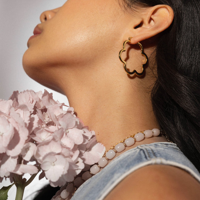 PURELEI Bloom Ohrringe aus 18K Gold Edelstahl Blütenform am Ohr, elegant und feminin, warmes Licht, hautnah.