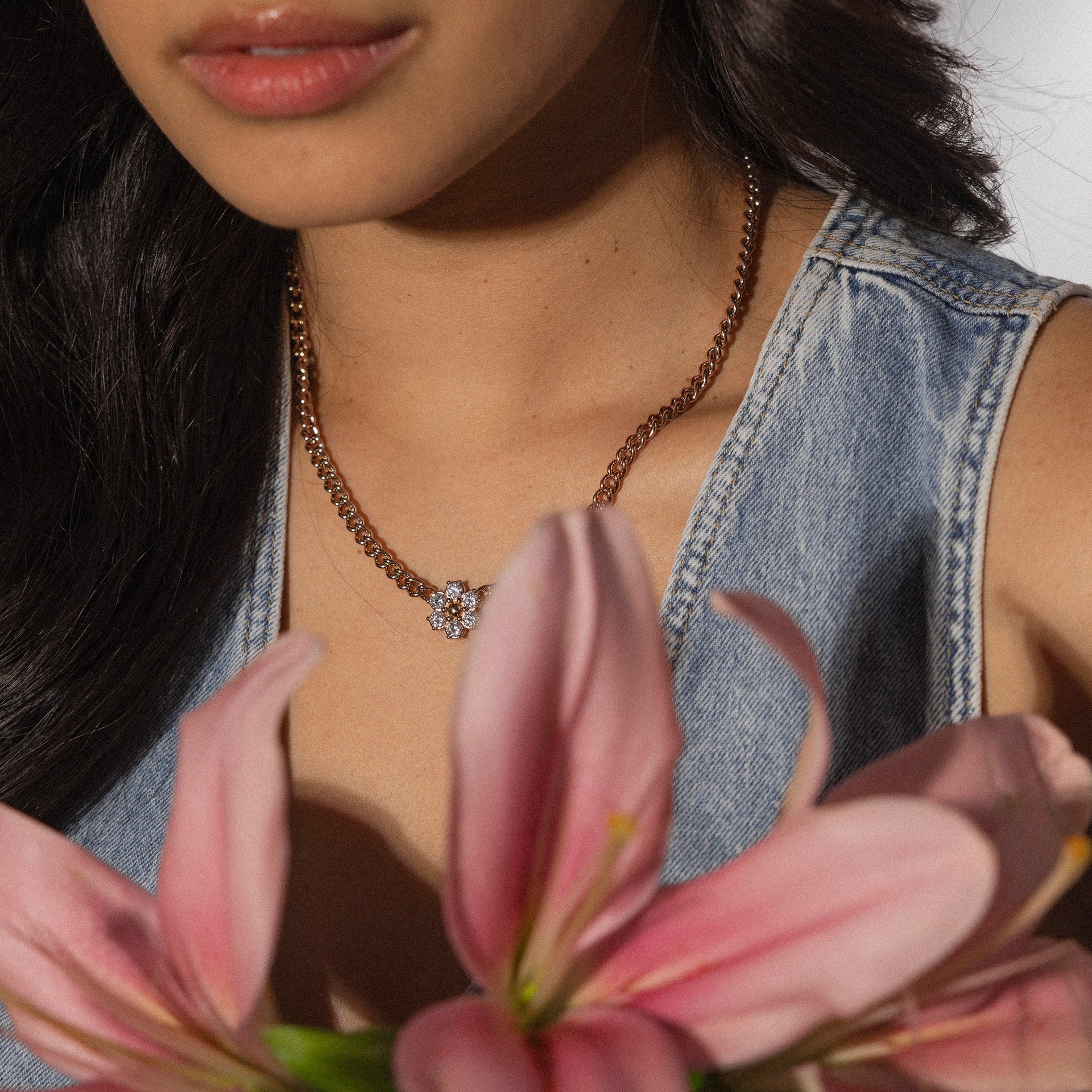 Roségoldene Kette mit blühendem Anhänger, getragen mit pinken Blumen, PURELEI.