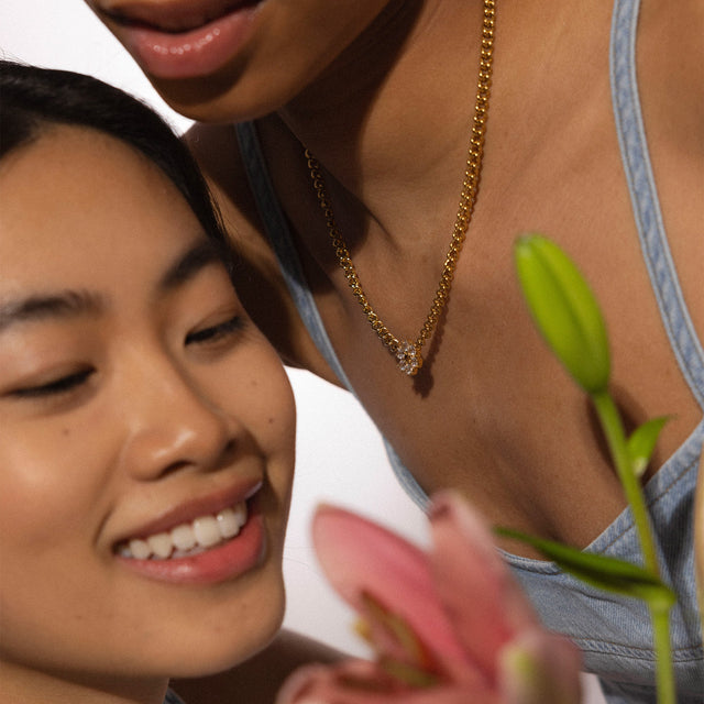 Roségoldene Kette mit funkelndem Anhänger, getragen in warmem Licht, PURELEI.