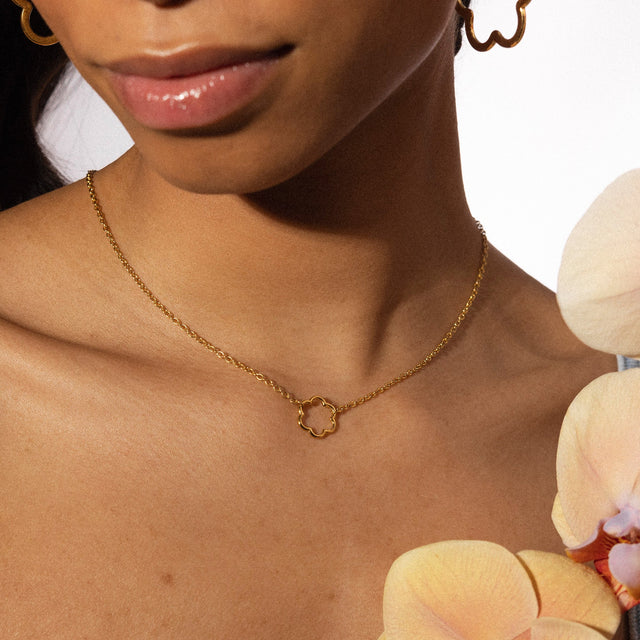 PURELEI Bloom Kette in 18K Gold mit zartem Blütenanhänger, elegant und feminin getragen am Hals.