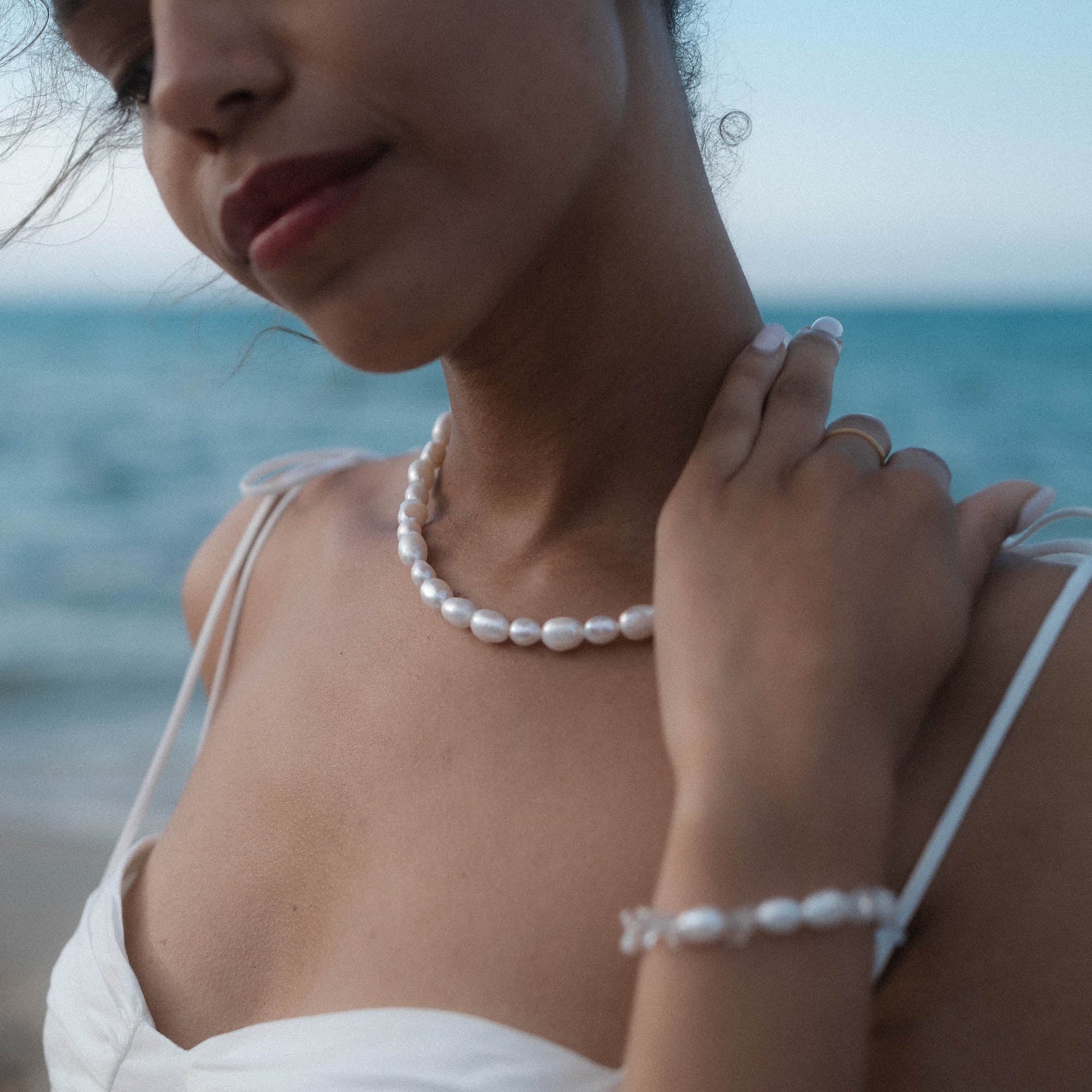 Moonlight Keshi Kette von PURELEI aus goldvergoldetem Edelstahl und großen Keshiperlen, elegant am Strand getragen.