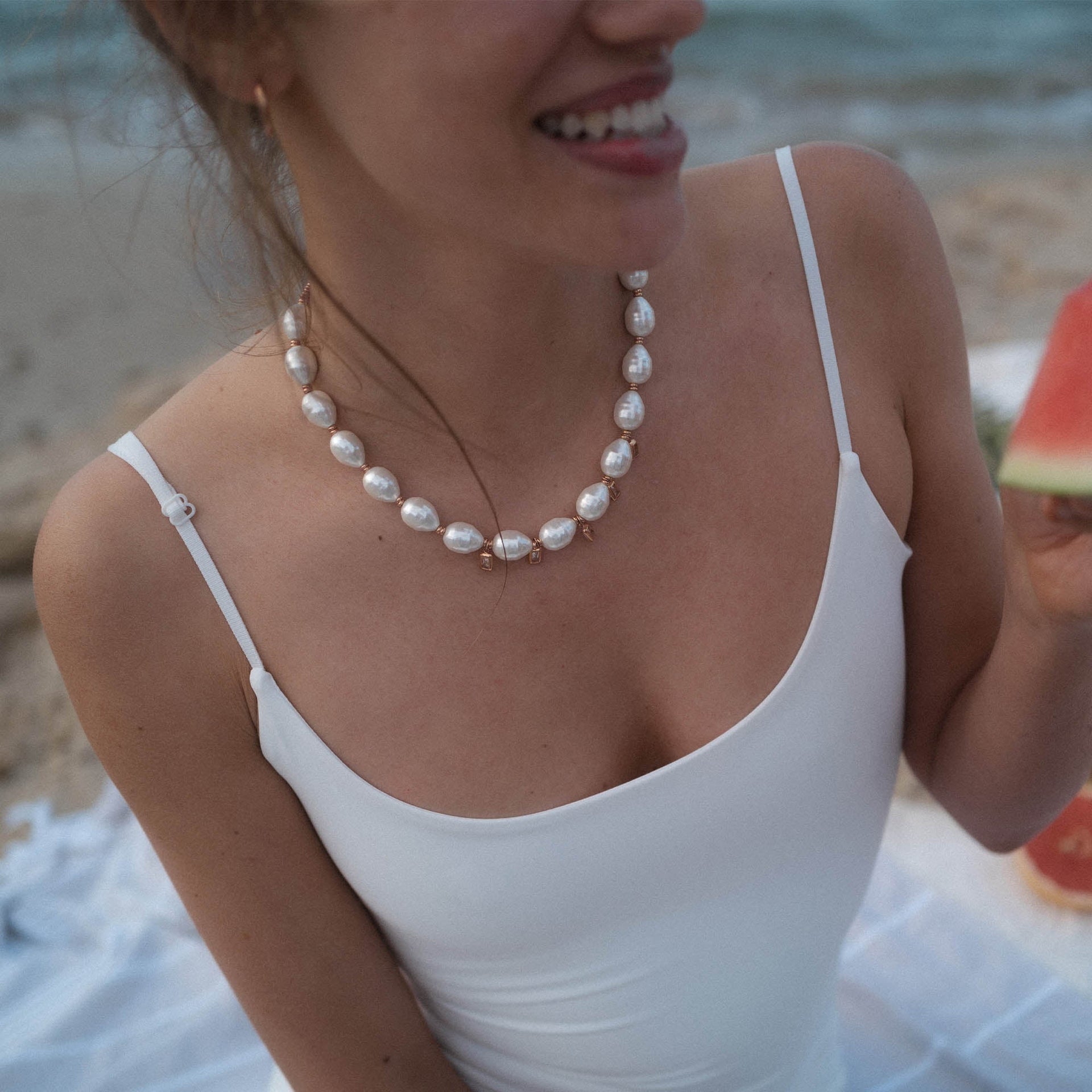 Perlenkette von PURELEI, elegant und strahlend, getragen am Strand.