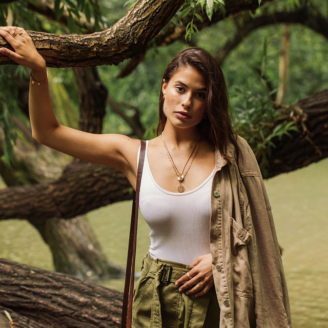 PURELEI Snake Coin Kette in Gold mit Schlangensymbol, warm und feminin im natürlichen Waldambiente getragen.