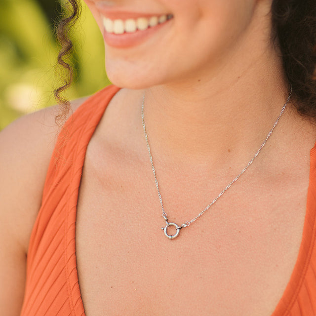 Silberne, nickelfreie Lokahi Charm Kette von PURELEI mit filigraner Kette, getragen im warmen Tageslicht.