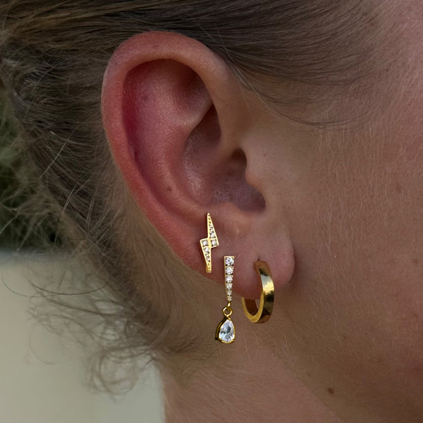 Silberne Ohrringe mit Blitz- und Tropfen-Design, getragen von PURELEI.