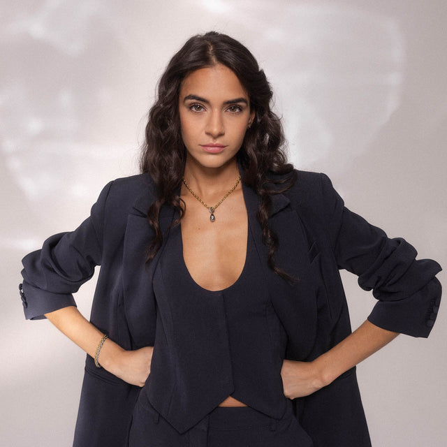 Elegante, schwarze PURELEI Kette mit Anhänger, getragen in stilvollem Outfit.