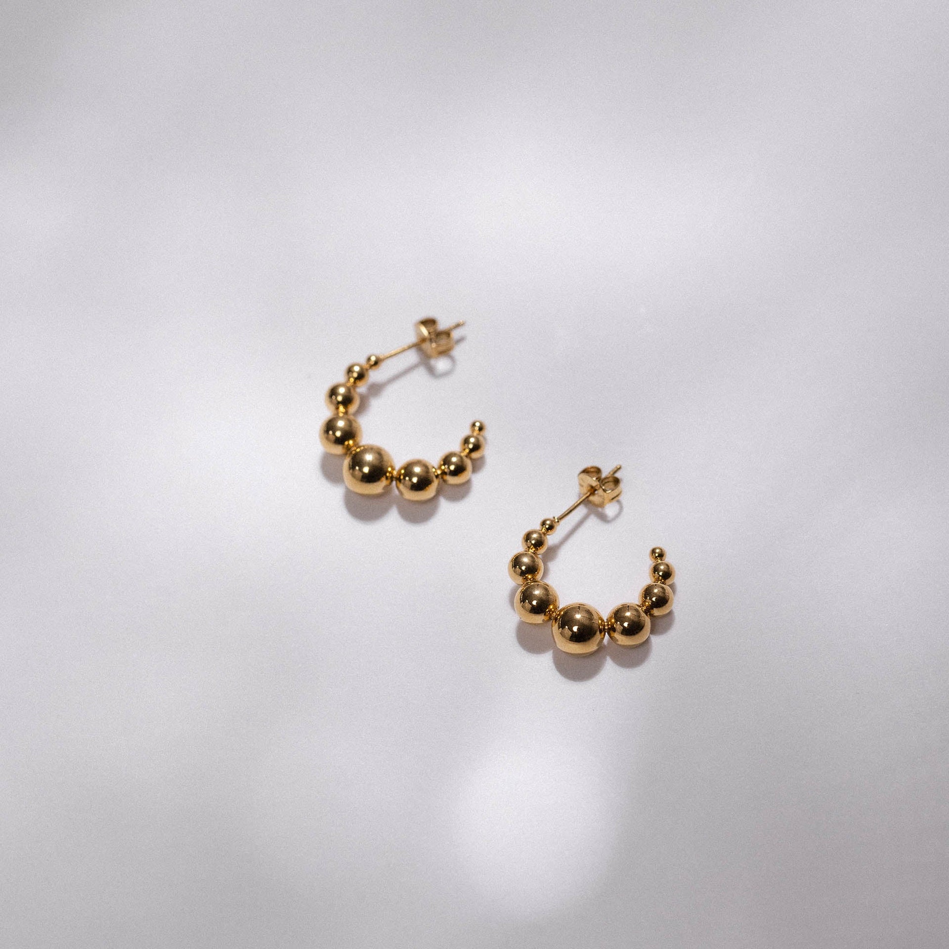 Goldene Creolen mit glänzenden Kugeln, elegant und modern, von PURELEI.