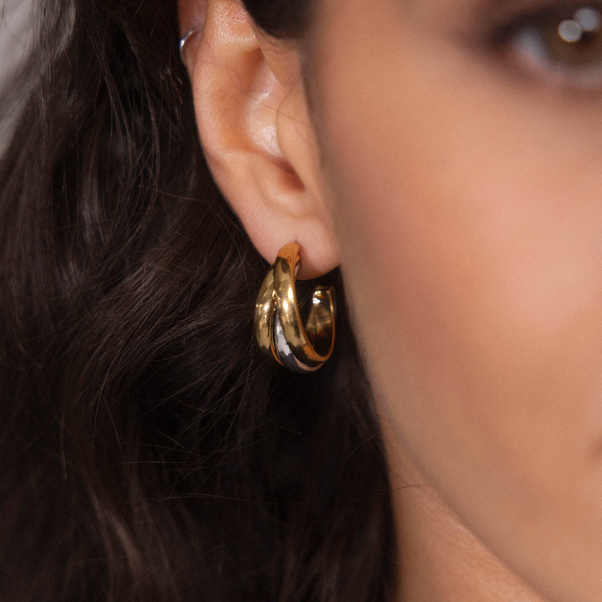 Roségoldene Creolen mit geschwungenem Design, getragen am Ohr, von PURELEI.