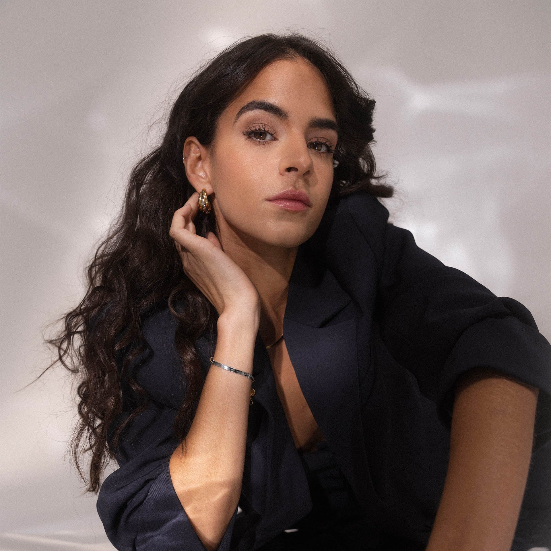 Elegante Creolen und zartes Armband von PURELEI, getragen in stilvollem Ambiente.