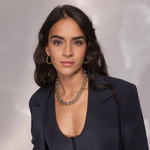 Silberne Kette und Creolen von PURELEI, elegant und modern, getragen mit einem blauen Outfit.