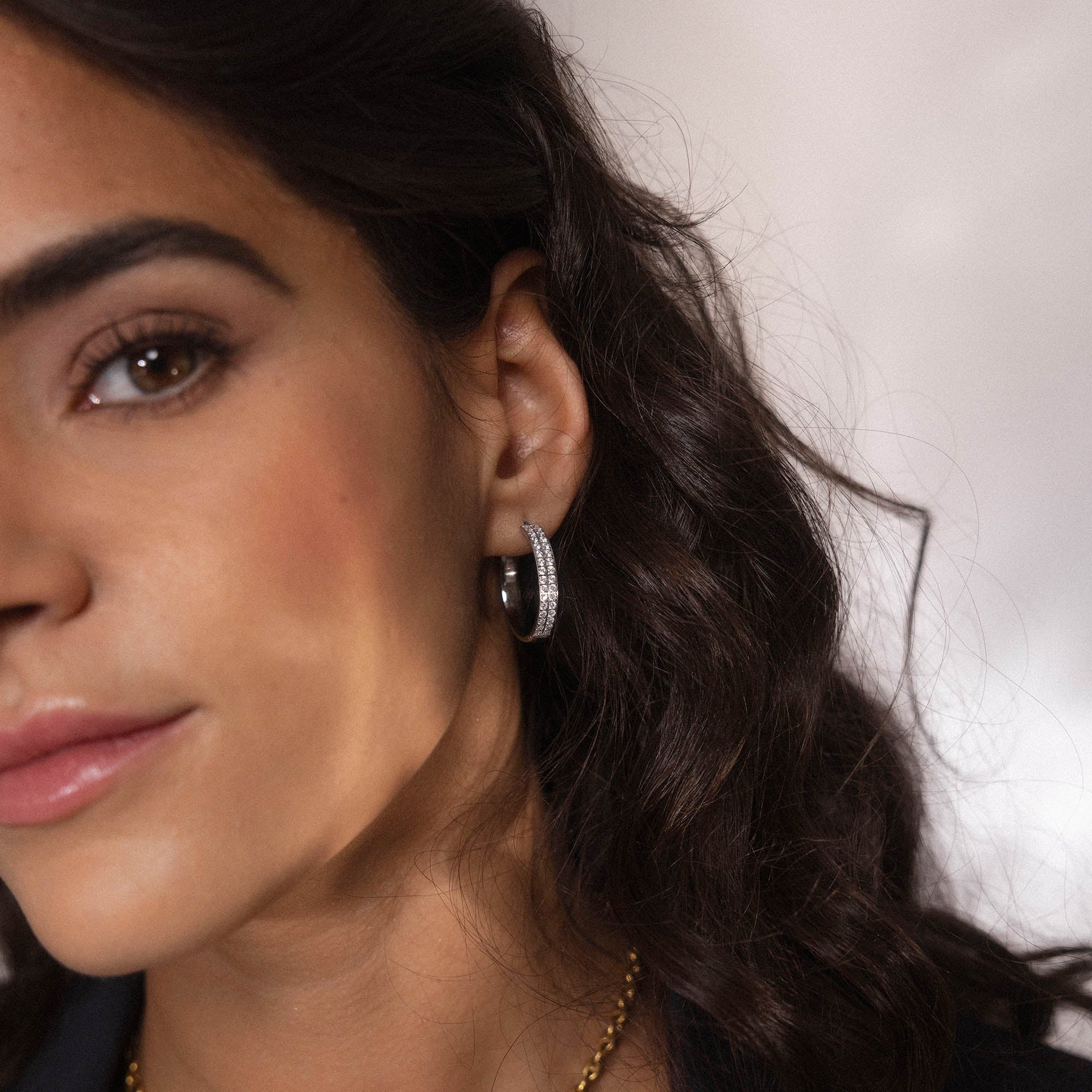 Silberne Creolen mit funkelnden Details, getragen von einer Frau, PURELEI.