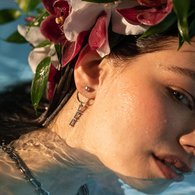 PURELEI Elua Ohrringe aus silberfarbenem Edelstahl mit schimmernder Perle, getragen im Wasser, nickelfrei.