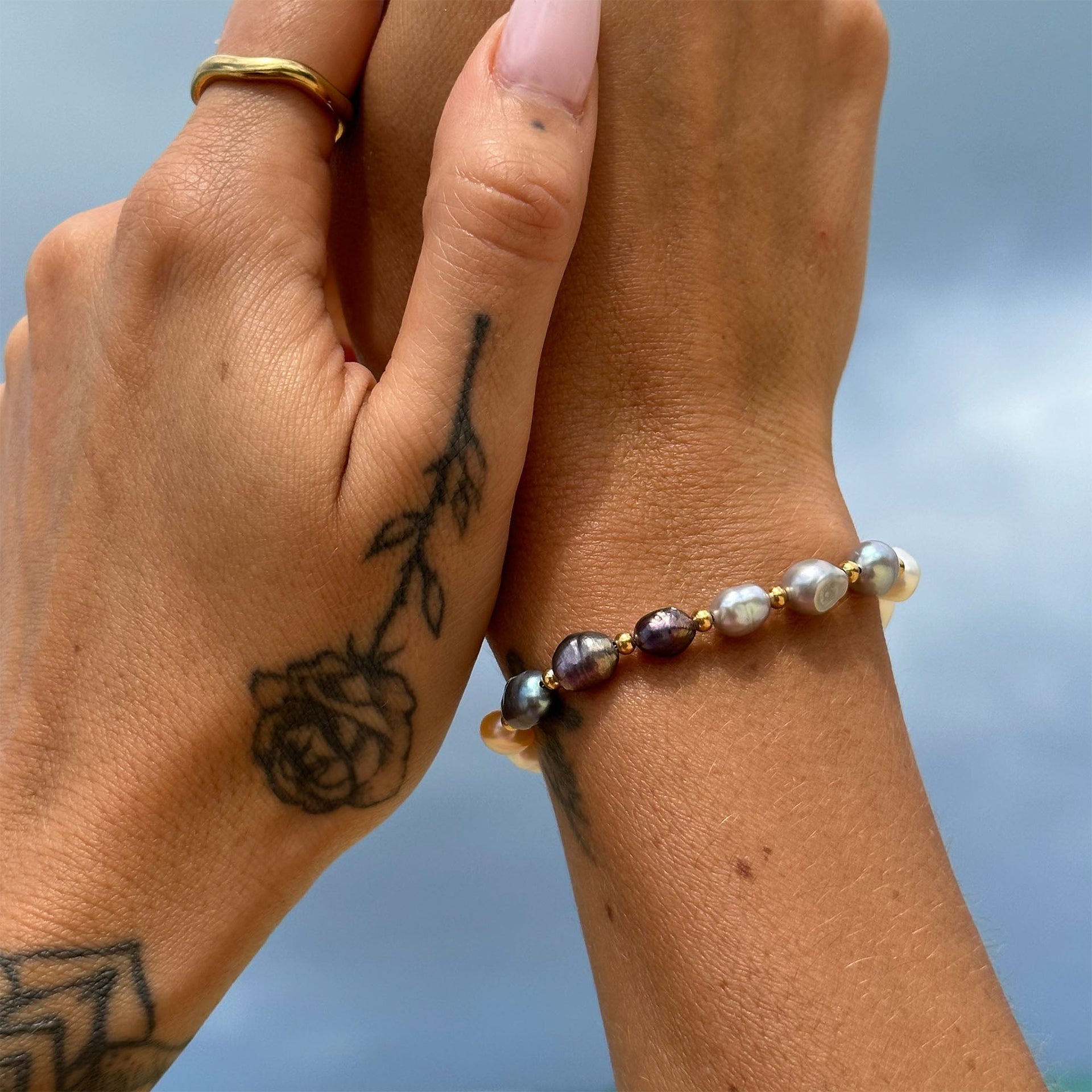 Elegantes Armband aus Perlen in sanften Tönen, getragen am Handgelenk, PURELEI.