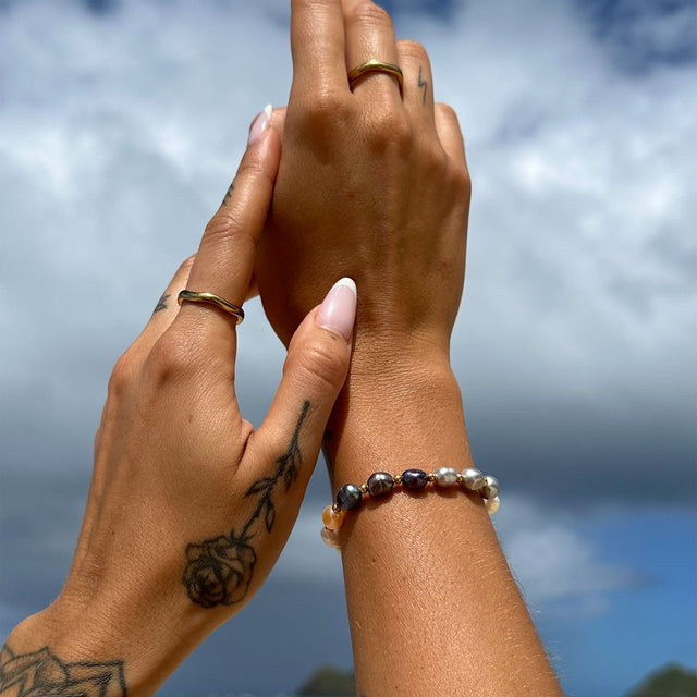 Zarte Ringe und Perlenarmband von PURELEI, elegant und feminin, mit tropischem Flair.