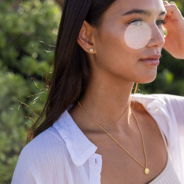 Roségoldene Kette mit Sonnenanhänger, getragen im Freien, PURELEI inspiriert.