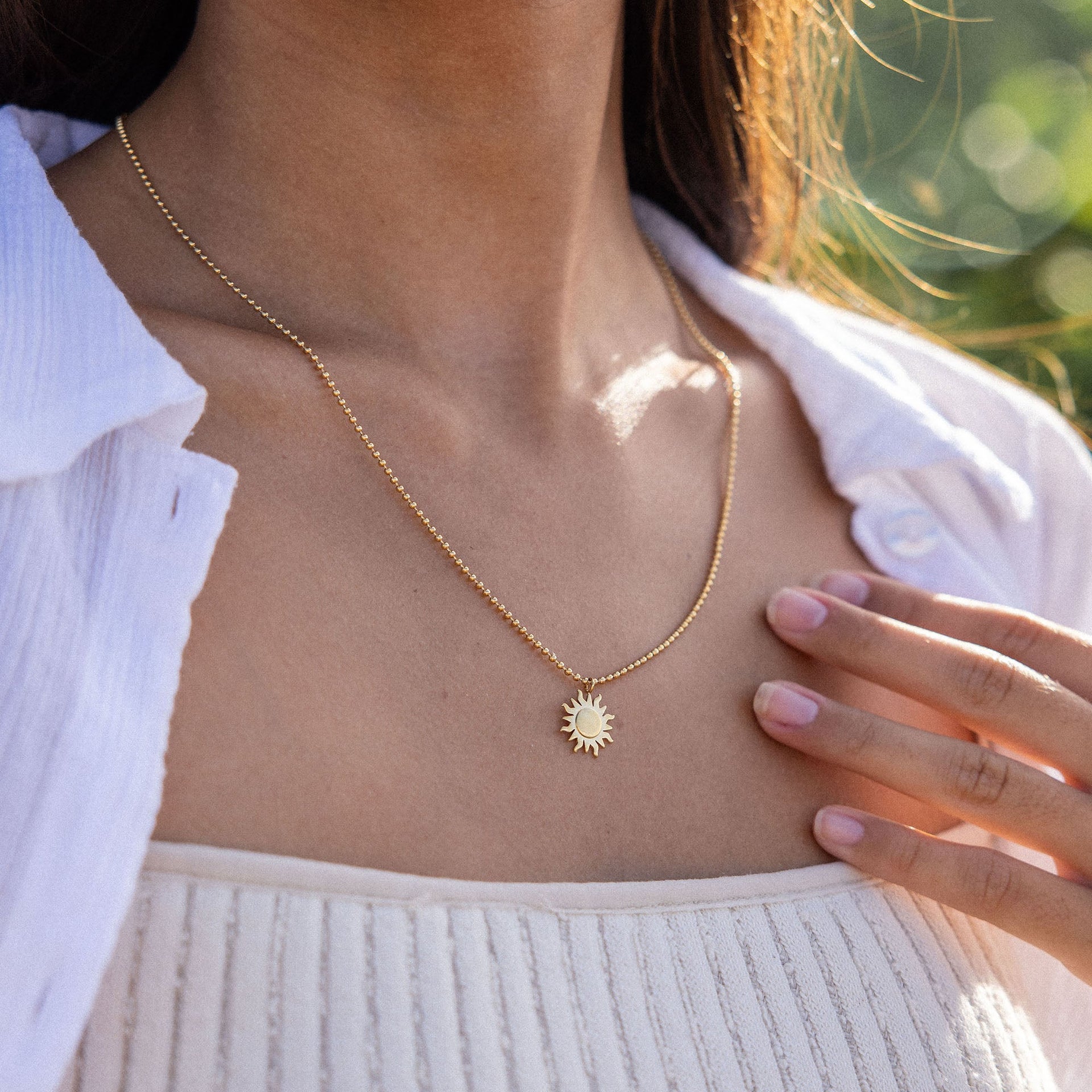 Roségoldene Kette mit Sonnenanhänger, getragen in natürlicher Umgebung – PURELEI.