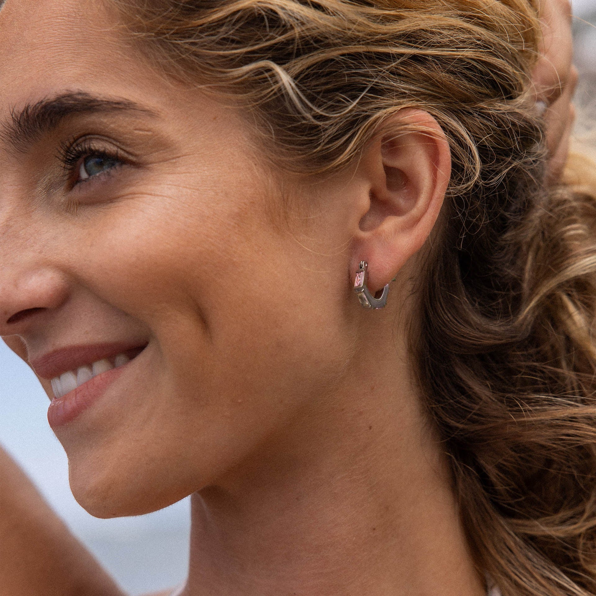 Silberne Creolen mit elegantem Design, getragen von einer lächelnden Frau, PURELEI.