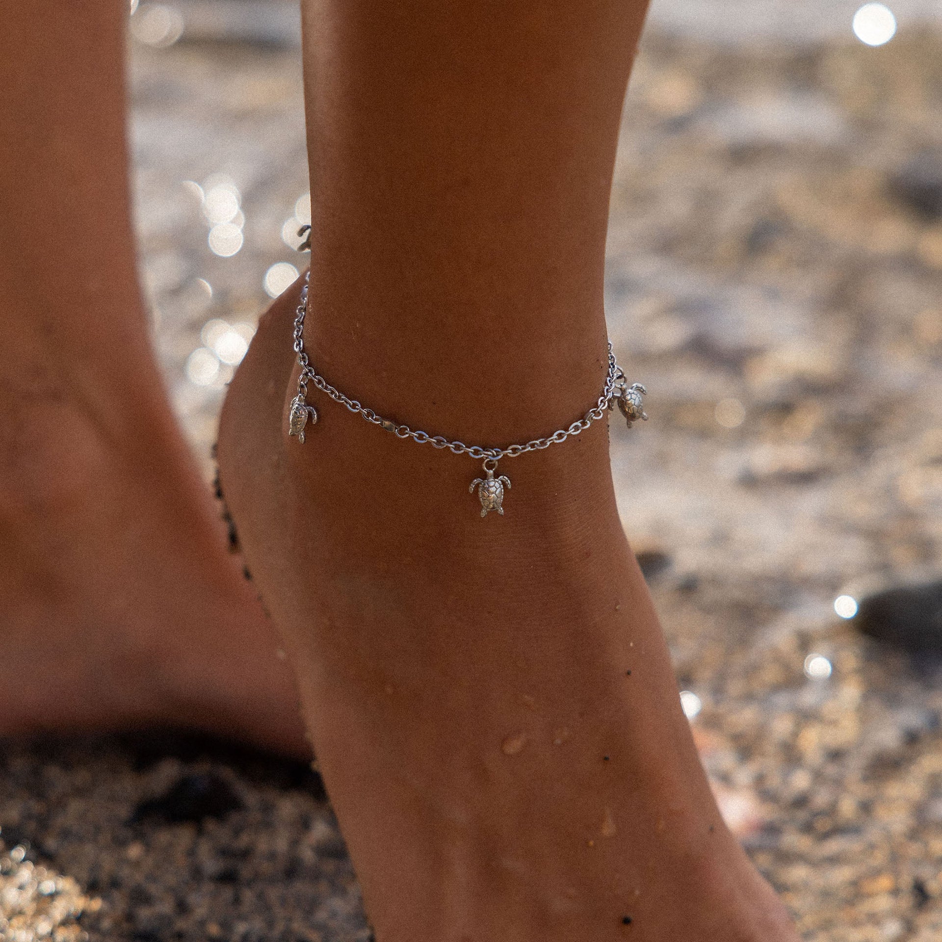 Silbernes Fußarmband mit Schildkröten-Anhängern, getragen am Strand – PURELEI.