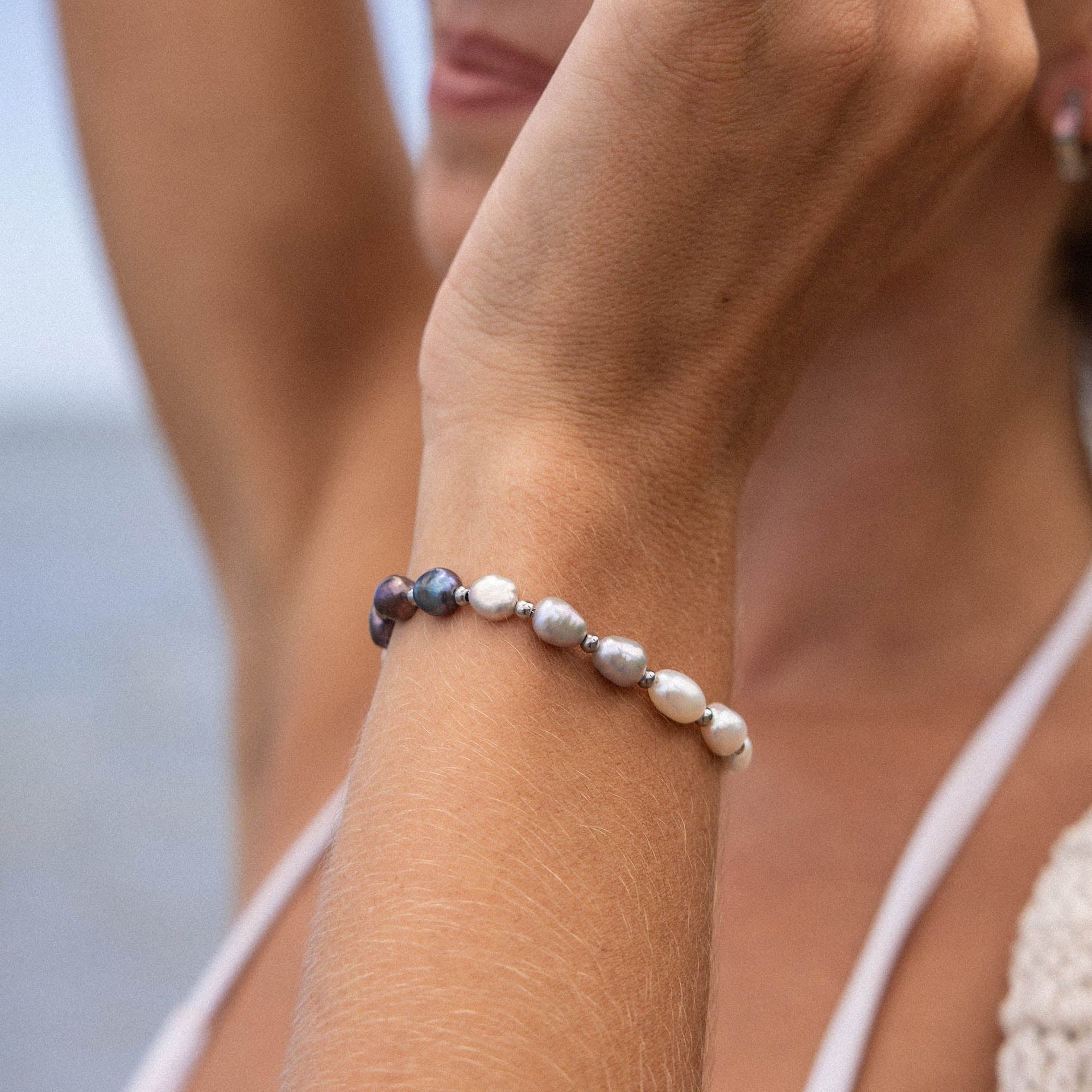 PURELEI Armband aus Muscheln in sanften Erdtönen, getragen am Handgelenk, beachy Stimmung.