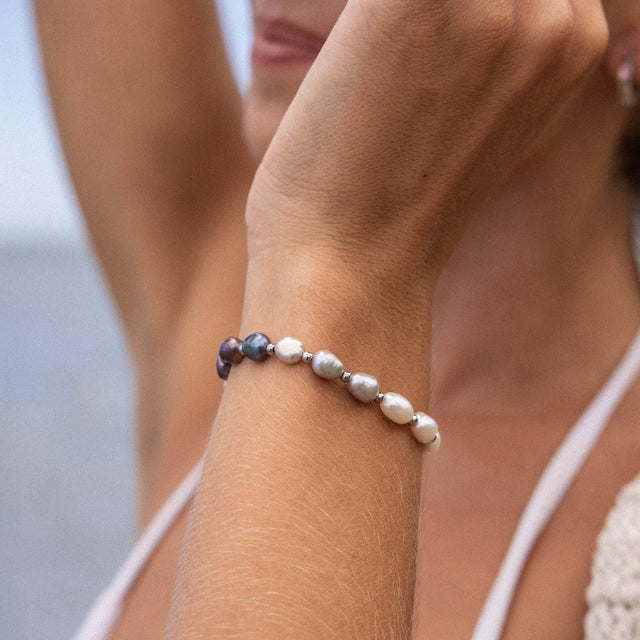 PURELEI Armband aus Muscheln in sanften Erdtönen, getragen am Handgelenk, beachy Stimmung.