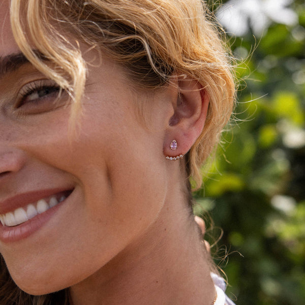 Adore Ohrringe von PURELEI mit rosafarbenen Zirkonia und weißem Edelstahl, elegant und feminin, am Ohr getragen.