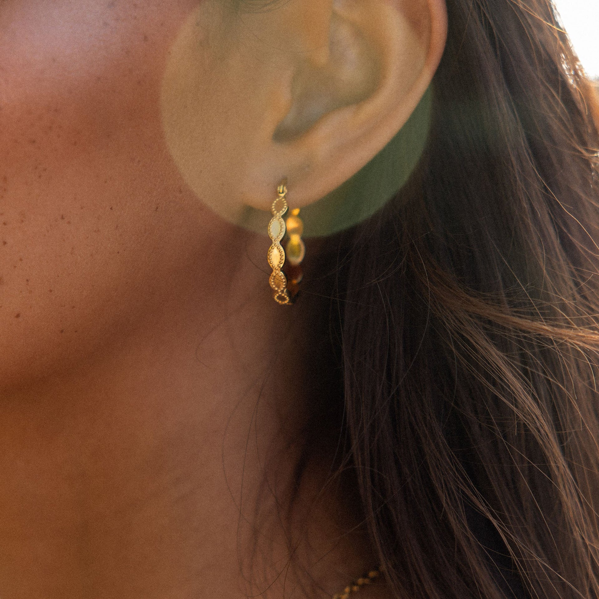 Roségoldene Creolen mit wellenförmigem Design, getragen, inspiriert von PURELEI.