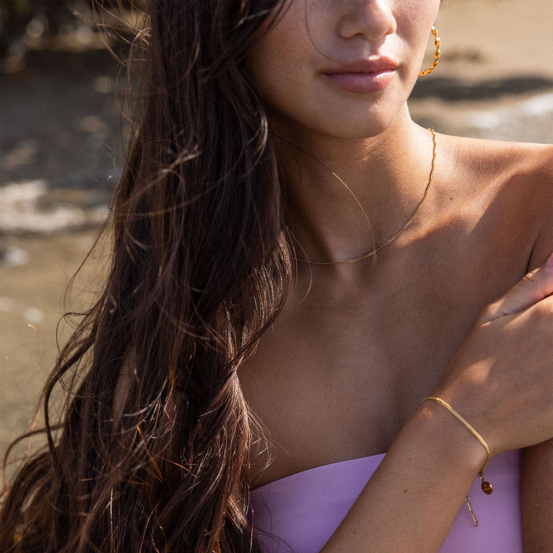 Golden glänzendes PURELEI Kanani Armband mit feiner Struktur am Handgelenk in natürlichem Licht, elegant und feminin.