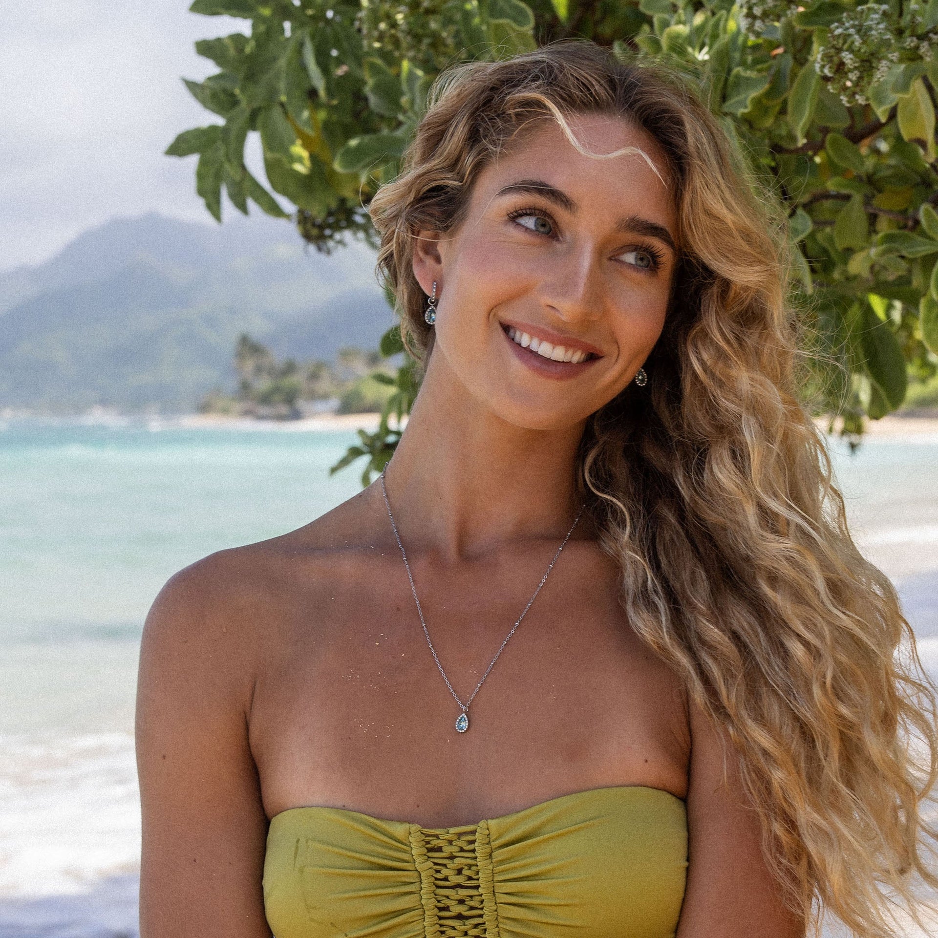 PURELEI Bellezza Kette aus goldbeschichtetem Edelstahl mit blauem Tropfenanhänger, feminin und elegant am Strand getragen