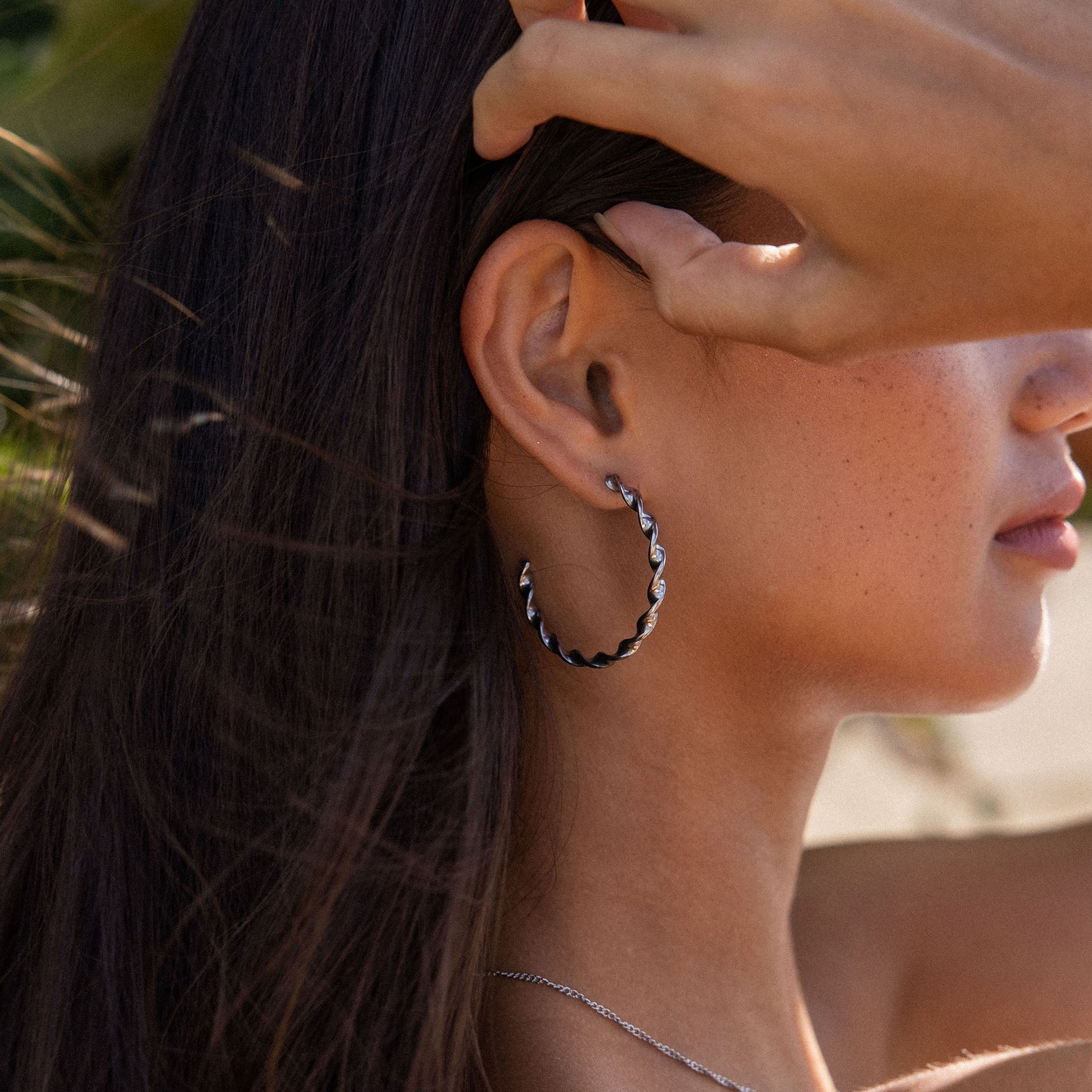 Kaula Creole Ohrringe aus nickelfreiem Silber mit feinem, gedrehtem Design, natürlich-elegant getragen.