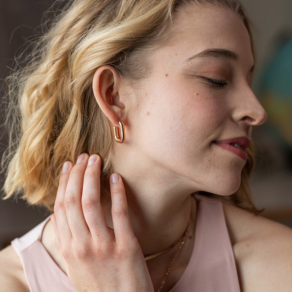 PURELEI Hula Ohrringe in 18K Roségold, elegant am Ohr getragen, feminine, warme Island-Ästhetik.