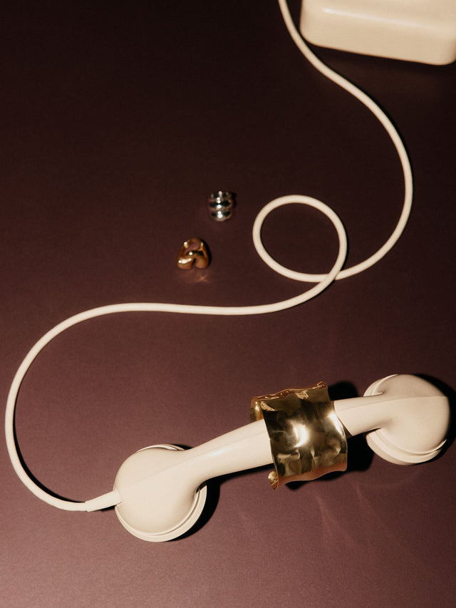 Silberner Ring auf weißem Telefonhörer, PURELEI inspiriert von Eleganz und Kreativität.