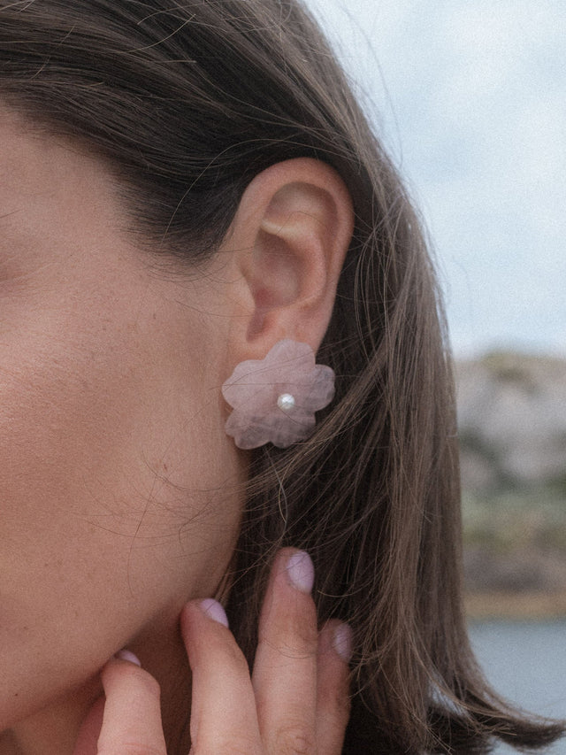 PURELEI Summer Breeze Ohrringe mit Rosenquarzblüte und Muschelperle, elegant und feminin am Ohr getragen.