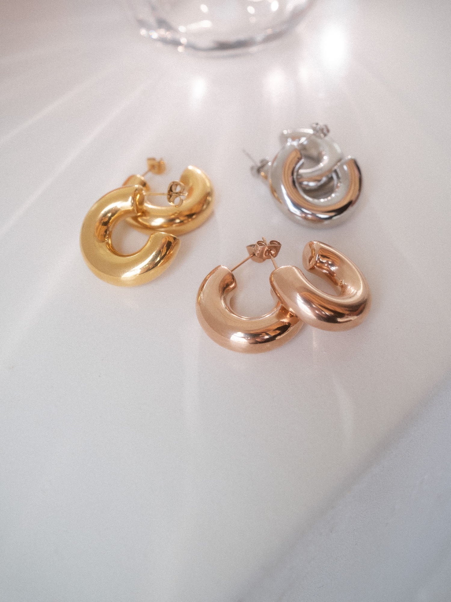 PURELEI Small Stellar Glow Ohrringe in Gold, Silber und Roségold, elegant schlicht und nickelfrei auf weißem Hintergrund