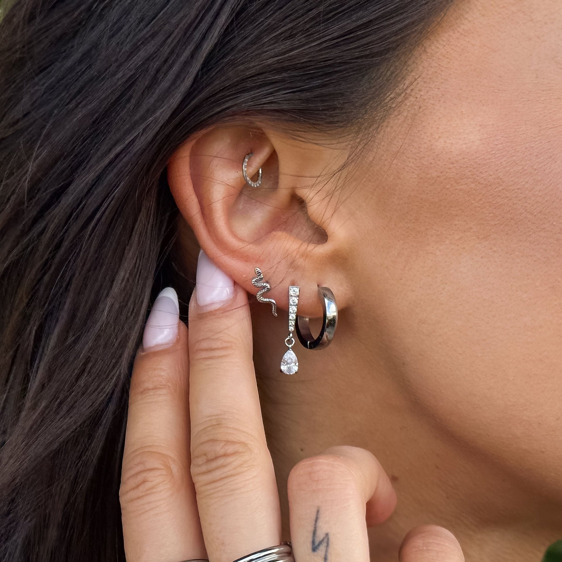 Silberne Ohrringe mit Schlange und Tropfenanhänger, getragen von PURELEI.