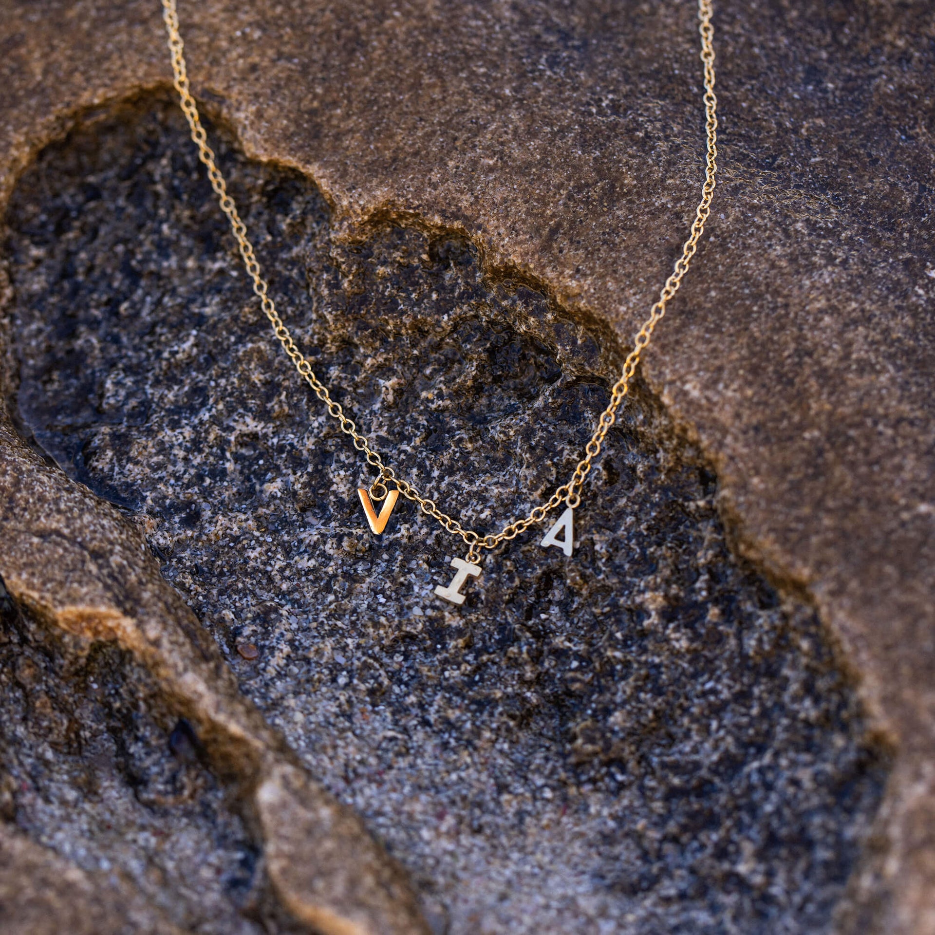 Feine Via Kette aus vergoldetem Edelstahl mit Buchstabenanhängern auf natürlichem Stein – elegant und zeitlos von PURELEI.
