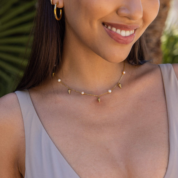 PURELEI Akala Kette aus vergoldetem Edelstahl mit Muschel-Anhängern und Süßwasserperlen, elegant am Hals getragen