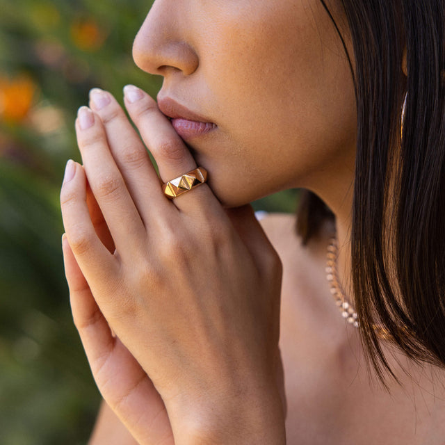 Be You Ring von PURELEI in 18K vergoldetem Edelstahl, mit markanten Nieten, getragen in natürlichem Licht.