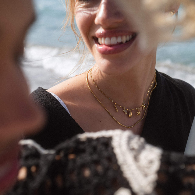 Zarte, roségoldene Kette mit Muschel-Anhängern, getragen am Strand – PURELEI Aloha-Vibes.